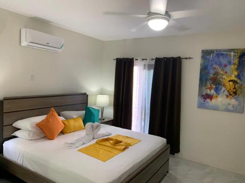 Tropical Rose Getaway في ديسكفري باي: غرفة نوم بسرير كبير مع وسائد برتقالية وصفراء