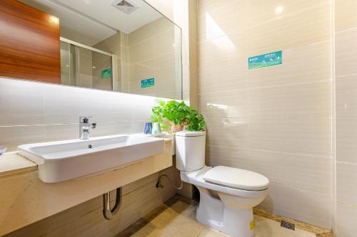 a bathroom with a sink and a toilet and a mirror at WAIFIDEN service Apartment Min Jian Fianance Branch--free shuttle during the Canton Fair in Guangzhou