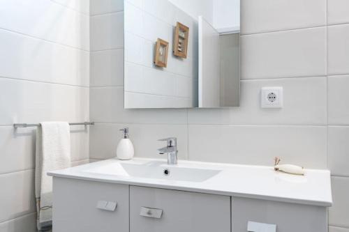 a white bathroom with a sink and a mirror at VIVA Casa do Galo in Porto