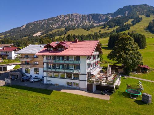 - une vue aérienne sur une maison dans les montagnes dans l'établissement Bergzeit - Hotel & Appartements, à Oberjoch