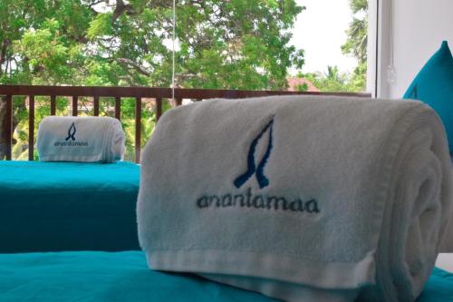 two pillows sitting on a bed with a blanket at Anantamaa Hotel in Trincomalee