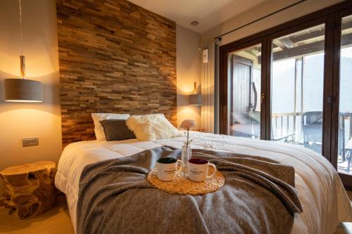 a bedroom with a large bed with a brick wall at Luxury Lodges by Grand Hotel Sitea in Sestriere