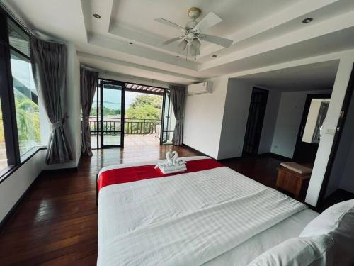 a bedroom with a large bed with a ceiling fan at villa vue mer in Amphoe Koksamui