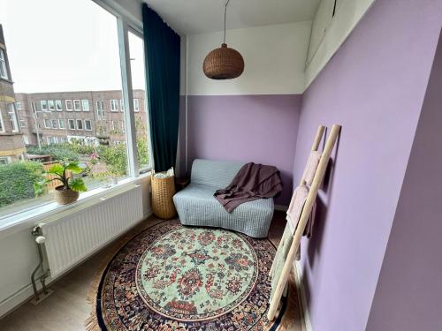 a purple room with a chair and a window at IVY - Classical & modern apartment in lovely neighbourhood near beach in The Hague