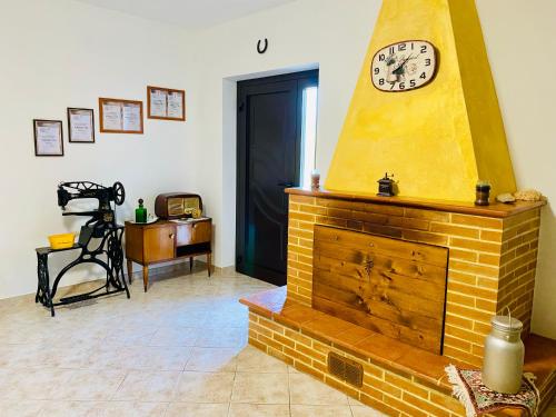 a living room with a brick fireplace with a clock at Anna&Franco Guest House in Isernia