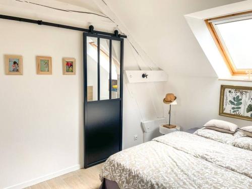 a bedroom with a bed and a black door at Charmant studio paisible in Alençon