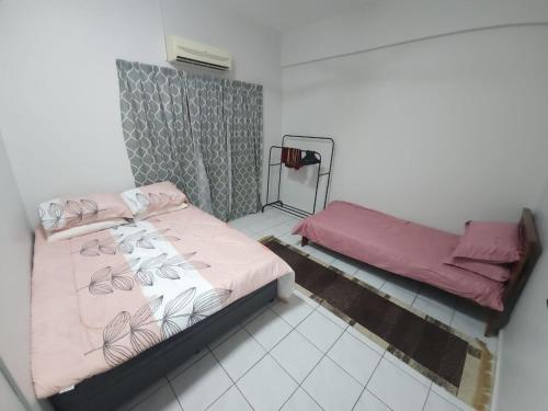a small room with two beds and a mirror at Uchi's Sunway Homestay in Petaling Jaya
