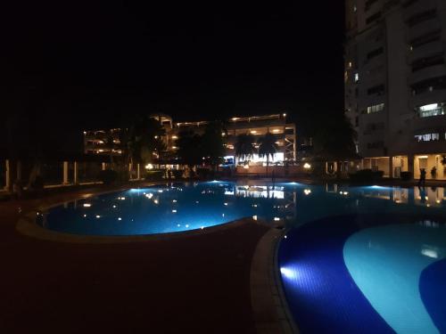 a large swimming pool at night with blue lights at Uchi's Sunway Homestay in Petaling Jaya