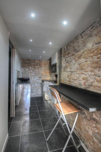- un bar avec un mur en pierre, une table et des chaises dans l'établissement Lyon centre, quartier Hôtel de ville, à Lyon