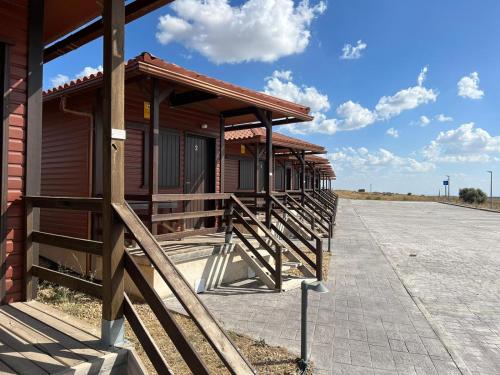 una fila de edificios de madera al lado de una carretera en Motel 112, en Algora