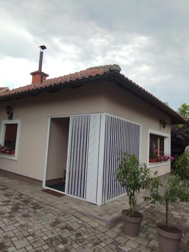 a small white house with an open door at Apartmani Nik Lux in Vrnjačka Banja