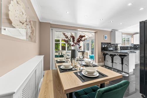 a dining room with a wooden table and chairs at Fantastic House in Bracknell - Garden - Games room in Bracknell