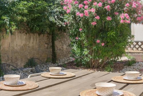 une table en bois avec des chapeaux de paille et des tasses dessus dans l'établissement TRIBUS-GITES URBAINS CARCASSONNE, à Carcassonne