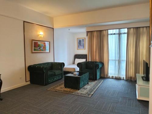 a living room with a couch and chairs in a hotel room at Luxy Service Apartment at Times Square KL in Kuala Lumpur