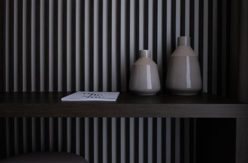 two white vases sitting on a table with a paper at Deep Blu Boutique Hotel in Żurrieq