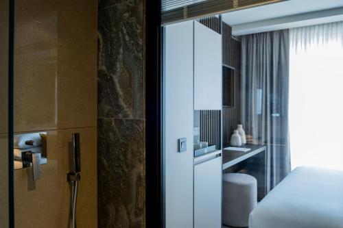 een hotelkamer met een bed en een badkamer bij Deep Blu Boutique Hotel in Żurrieq