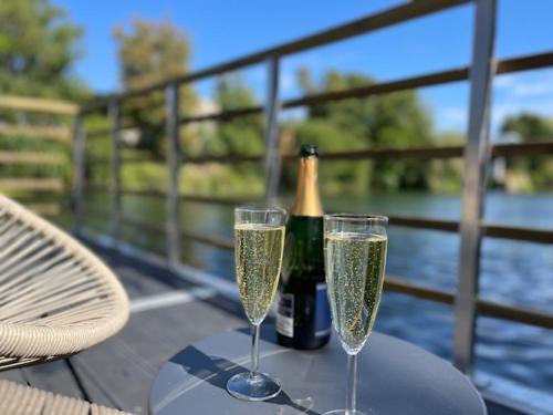 - deux verres à champagne sur une table avec une bouteille de champagne dans l'établissement Gîte Seine & Nature Le Bâbord, à Bennecourt