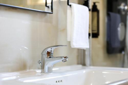 a bathroom sink with a faucet and a mirror at Noa Apartments in Vlorë