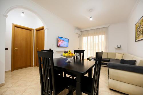 a dining room and living room with a table and chairs at Noa Apartments in Vlorë