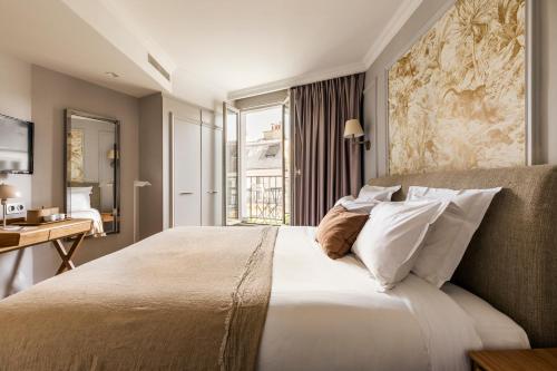 um quarto com uma cama grande e uma janela em Maison Pigalle em Paris