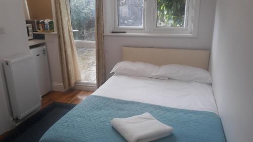 een slaapkamer met een bed met twee handdoeken erop bij Luxury studio flat in Londen