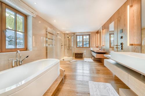 un ampio bagno con due lavandini e una vasca di Chalet Lilly - Luxury by A-Appartments a Zug