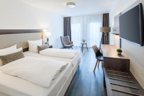 Habitación de hotel con 2 camas y TV de pantalla plana. en Hotel Newton Ludwigshafen, en Ludwigshafen am Rhein