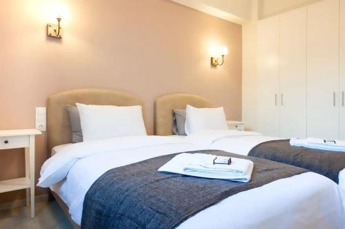 アテネにあるSunlit Apartment with Acropolis Viewのホテルルーム内のベッド2台 ベッド上にバスローブを用意しています。