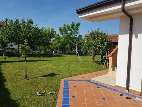 ein Haus mit einer gefliesten Terrasse mit Garten in der Unterkunft Deliziosa Villetta con Giardino in Marina di Casalvelino