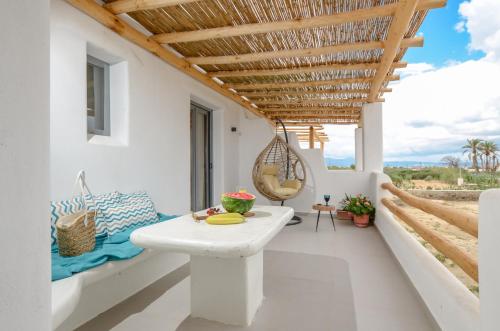 - un balcon blanc avec une table et une chaise dans l'établissement White Cocoon Exclusive villas, à Naxos Chora
