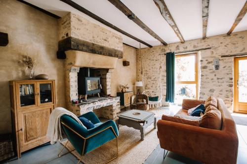 a living room with two couches and a fireplace at Ecolodge La Belle Verte in Saint-Mʼhervé