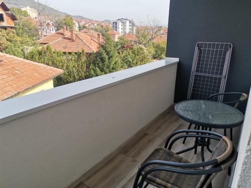 balcón con 2 sillas, mesa y ventana en Nikolici - Free Parking en Vranje