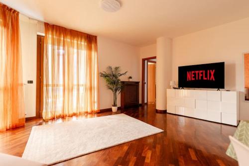 sala de estar con TV y alfombra blanca en Attico vicino Milano, MXP, Rho Fiera, en Busto Arsizio