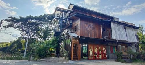 BAAN9NAN Home Lodge في نان: مبنى خشبي مع شرفة على شارع