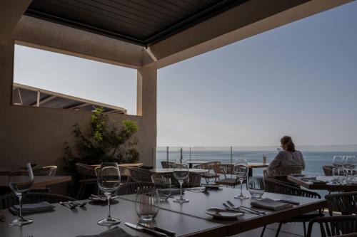 a restaurant with tables and chairs with a woman in the background at Deep Blu Boutique Hotel in Żurrieq