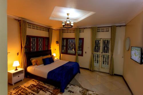 a bedroom with a king sized bed and two windows at The Mbuya Residence in Kampala