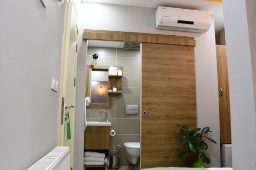 a bathroom with a toilet and a wooden door at Cibali Hotel Istanbul in Istanbul