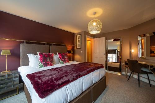a hotel room with a large bed and a desk at At Home in Shrewsbury