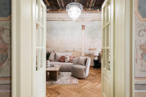 ein Wohnzimmer mit einem Sofa und einem Kronleuchter in der Unterkunft Gallery 7 - LoftAffair Collection in Krakau
