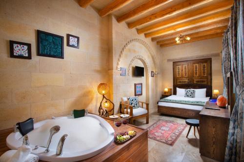 a bathroom with a tub and a bedroom with a bed at Simera in Cappadocia - Special Class in Uchisar