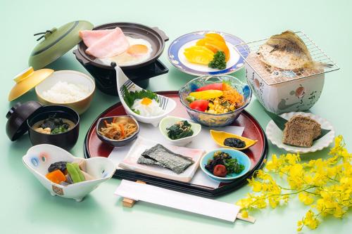 a table with plates of food and bowls of food at Umino Hotel Hajime in Beppu