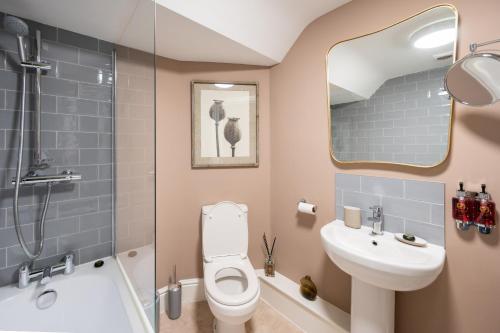 a bathroom with a toilet and a sink and a shower at At Home in Shrewsbury