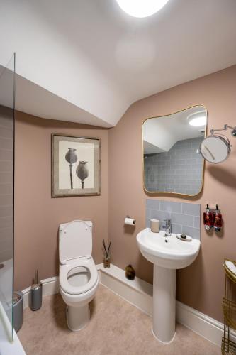 a bathroom with a toilet and a sink at At Home Apartments in Shrewsbury
