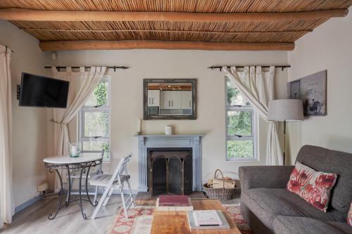 a living room with a couch and a fireplace at Little Willow Brooke in Franschhoek