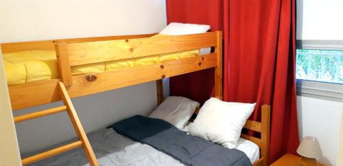 a bedroom with a bunk bed with a ladder and a bunk bedoublethritisthritis at T2 Terrasse, Bormes Les Mimosas La Faviere, 5 mn à pieds des plages et commerces in Bormes-les-Mimosas