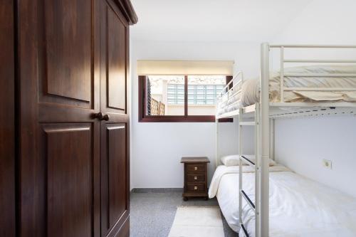 a bedroom with two bunk beds and a window at EDEN RENTALS Candelaria Melicoton Scape in Candelaria