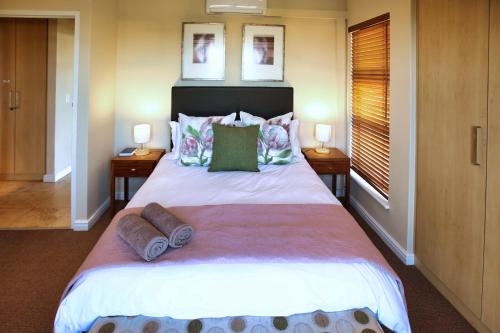 una camera da letto con un grande letto con due comodini di Ellefsen Golf Suite 115 a Langebaan