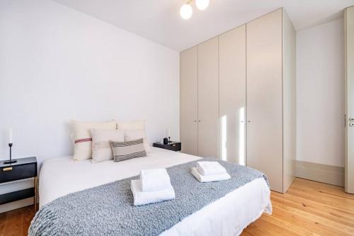 - une chambre blanche avec un grand lit et 2 serviettes dans l'établissement A Formosa - Premium @ Porto City Centre, à Porto