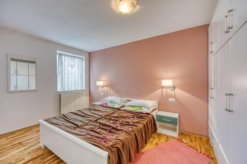 1 dormitorio con cama y pared de color rosa en Villa Mare, en Rovinj