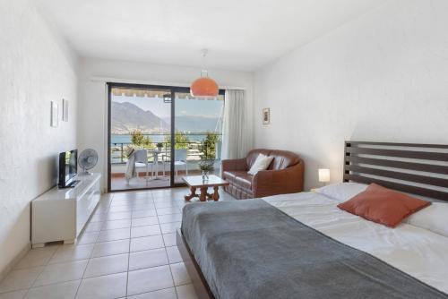 um quarto com uma cama e uma sala de estar em Aparthotel Al Lago em Locarno